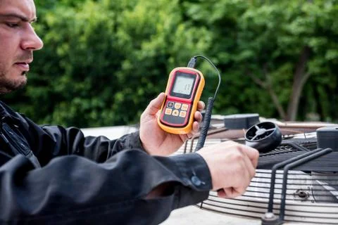Technician use hand-held anemometer measuring air flowing measurement Stock Photos