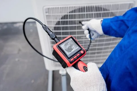 The technician uses a digital camera to check the clogging of the heat exchanger Stock Photos