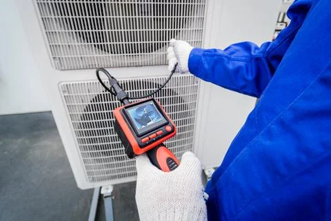 The technician uses a digital camera to check the clogging of the heat exchanger Stock Photos
