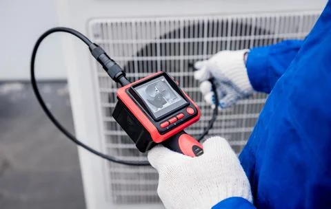 The technician uses a digital camera to check the clogging of the heat exchanger Stock Photos
