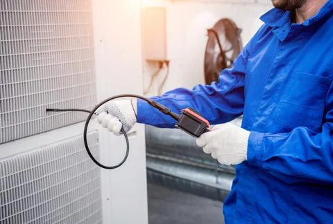 The technician uses a digital camera to check the clogging of the heat exchanger Stock Photos