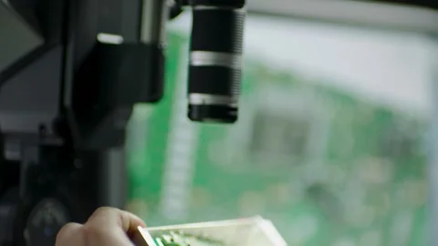 Technician Uses Microscope to Examine Circuit Board in Electronics Laboratory Stock Footage 334541505