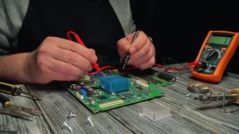 Technician uses multimeter to test electronic circuit board components with Stock Footage 337163750