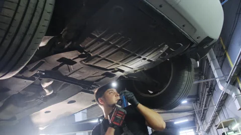 Technician uses special tool to secure wheel inspecting structure Stock Footage 317640865