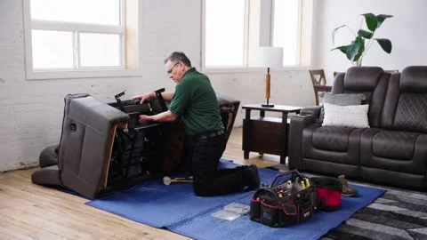 Technician Uses Tie-Down Straps to Secure Upholstery on Tilted Leather Sofa Video stock 307833686
