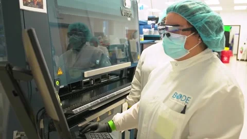 A technician uses a touchscreen on a laboratory instrument at a crime Video stock 345299240