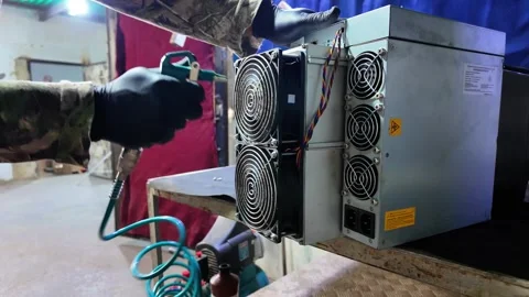 Technician using air compressor to clean Bitcoin mining hardware Stock Footage 327556797