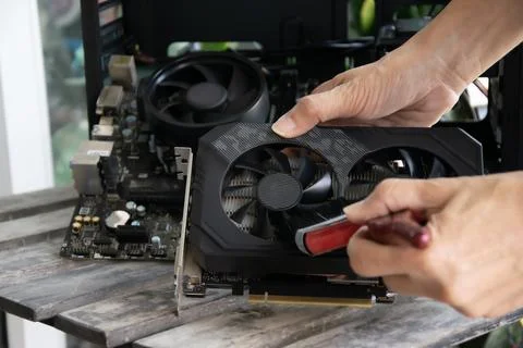 A technician is using a brush to clean the graphics card. Stock Photos