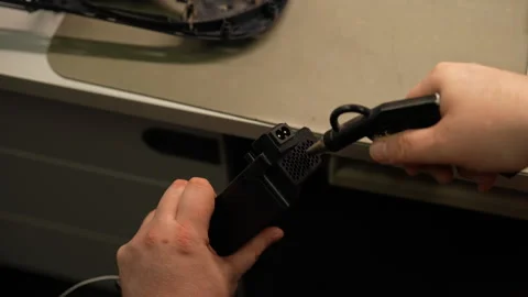 Technician using compressed air to clean dust and debris from game console part Stock Footage 310622682