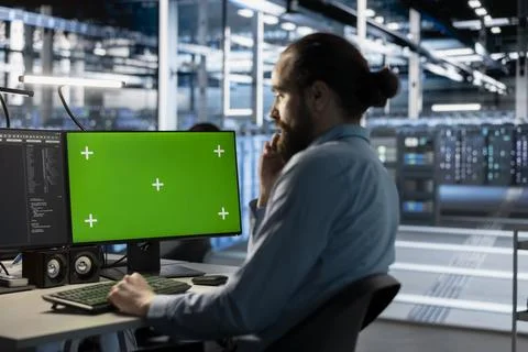 Technician using green screen mockup PC in data center to update servers tech Stock Photos