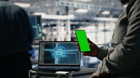 Technician using green screen smartphone in server hub while optimizing AI Video stock 314686008