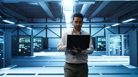 Technician using laptop in data center, managing servers Stock Photos