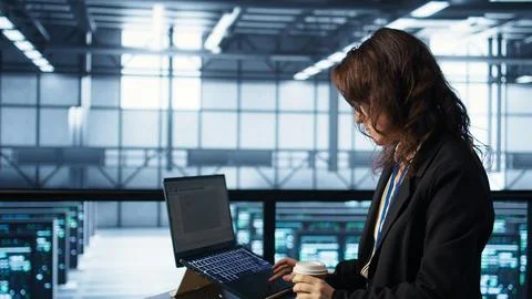 Technician using laptop in data center, finetuning network protocols Stock Photos