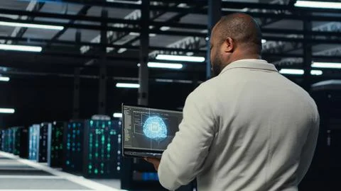 Technician using laptop in data center, managing server virtualization 스톡 사진