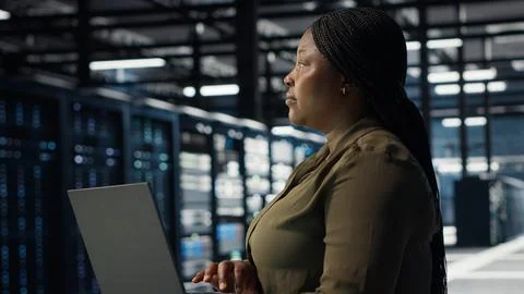 Technician using laptop in high tech data center, integrating new technologies Stockfoto's