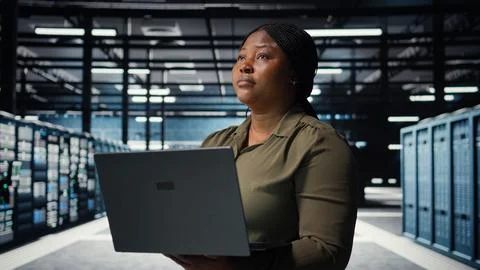 Technician using laptop in high tech data center, integrating new technologies Stock Photos