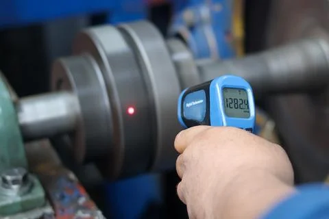 Technician Using Laser Digital Tachometer to Measure Shaft RPM. Stock Photos