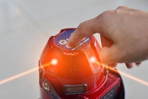 The technician is using a laser level. Stock Photos