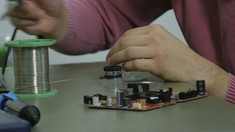 Technician using magnifier and soldering iron while installing motherboard. Stock Footage 71215321