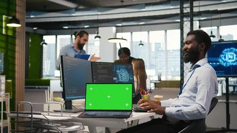 Technician using mockup laptop next to office coworkers developing applications Stock Photos