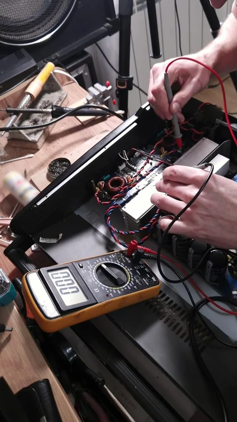 Technician Using Multimeter Probes to Test Electronic Circuit Board on Workbench Stock Footage 339001793