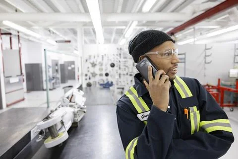 Technician using phone in workshop Stock Photos