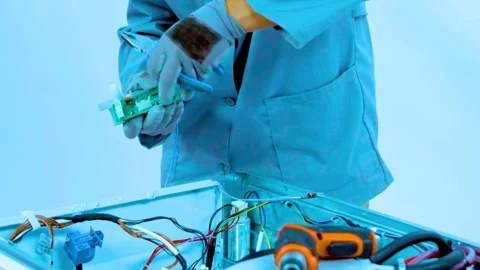 Technician using pliers to repair circuit board inside home appliance unit Stock-Footage 342905538