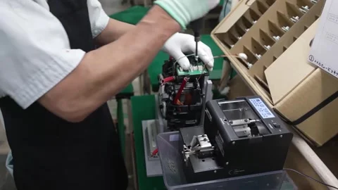 Technician using precision electric screwdriver to secure electronic components Stockbeeldmateriaal 334966452