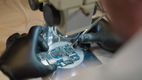 Technician Using Precision Tool on Circuit Under Microscope Stock Footage 282298777