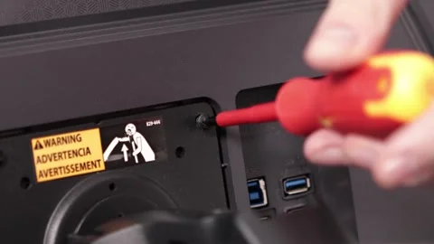 Technician using a screwdriver on a computer monitor back panel, performing.. Stock Footage 324964446