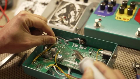 Technician using a soldering iron to connect wires on the electronic board Stock Footage 342444418