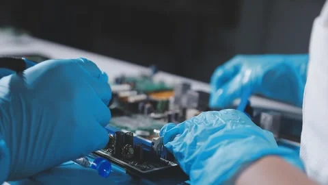 Technician using soldering iron on electronic circuit board for hardware re.. Stock Footage 345605938