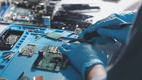Technician using soldering iron on electronic circuit board for hardware re.. Stock Footage 345605973