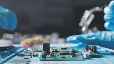 Technician using soldering iron on electronic circuit board for hardware re.. Stock Footage 345605983