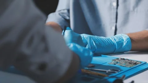 Technician using soldering iron on electronic circuit board for hardware re.. Stock Footage 345605989