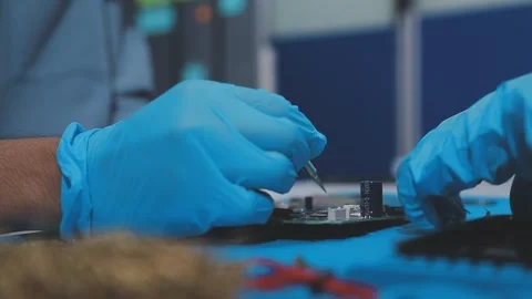 Technician using soldering iron on electronic circuit board for hardware re.. Stock Footage 345605994