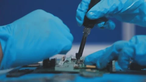 Technician using soldering iron on electronic circuit board for hardware re.. Stock Footage 345606002