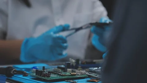 Technician using soldering iron on electronic circuit board for hardware re.. Stock Footage 345606009