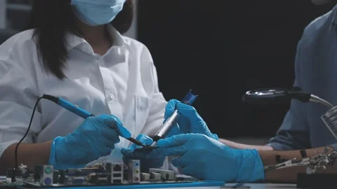 Technician using soldering iron on electronic circuit board for hardware re.. Stock Footage 345606029