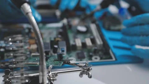 Technician using soldering iron on electronic circuit board for hardware re.. Stock Footage 345606056