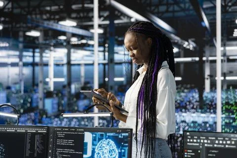 Technician using tablet in data center, configuring hardware for AI tasks Stockfoto's