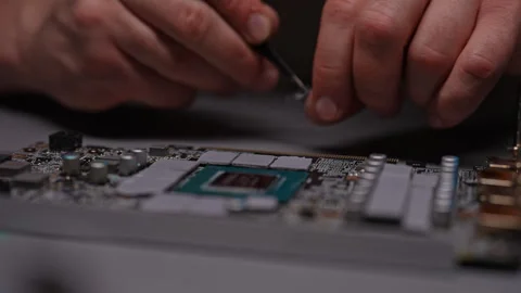Technician using tweezers applying new thermal pads to GPU of modern gaming PC Stock Footage 293741640