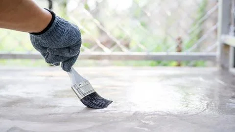 Technician using a varnish paint with a cement floor. Stock Photos