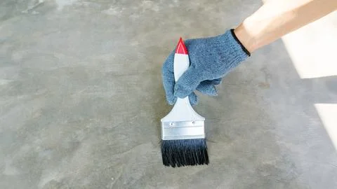 Technician using a varnish paint with a cement floor. Stock Photos