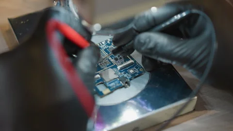 Technician Using Voltmeter Wire to Test Circuit Under Microscope Stock Footage 282299091