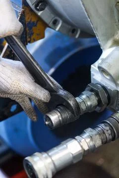 Technician Using Wrench On Hydraulic Fitting. Stock Photos