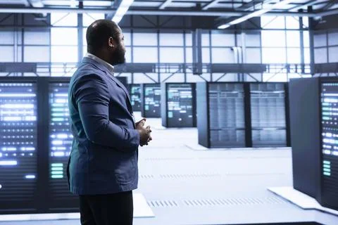 Technician walking in server hub, checking hardware Stock Photos