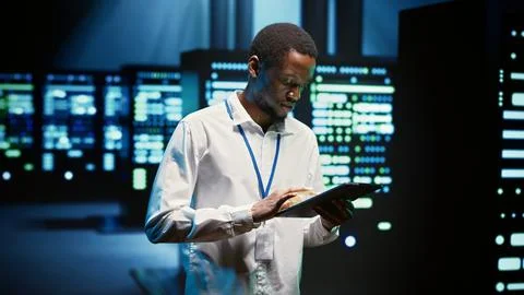 Technician walking through server rigs Stock Photos