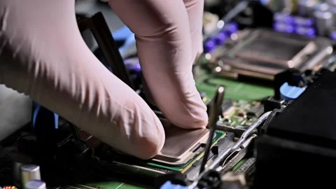 A technician wearing gloves installs a CPU onto a computer motherboard, dem.. Stock Footage 312072055