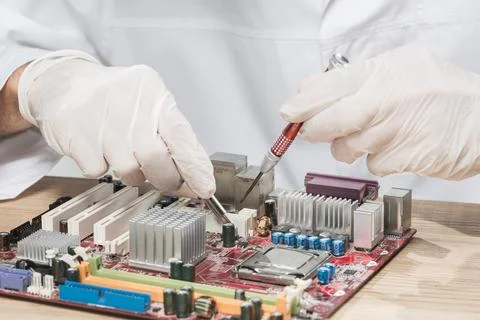 Technician wearing gloves working computer motherboard Stock Photos